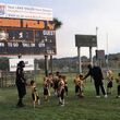 Kids and coaches on Legion Field grass